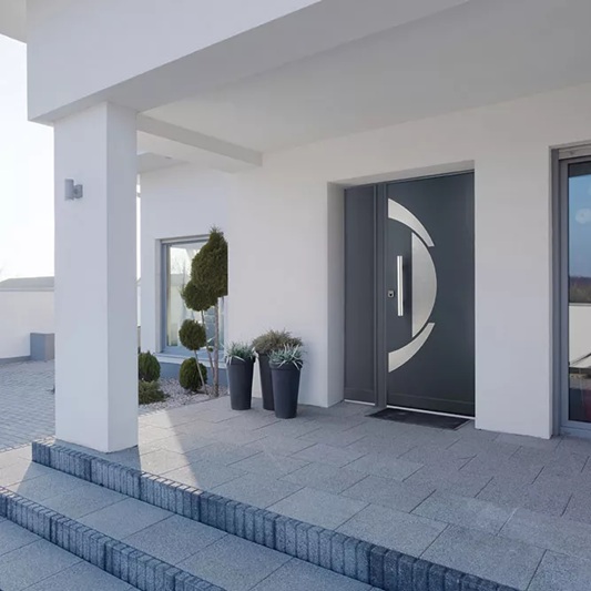 Puerta acorazada Fichet Stylea SL gris con diseño contemporáneo instalada en la entrada de un chalet.