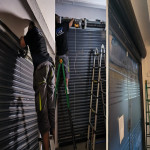 Operarios cualificados ejecutando la motorización técnica de un cierre metálico de seguridad en local comercial.